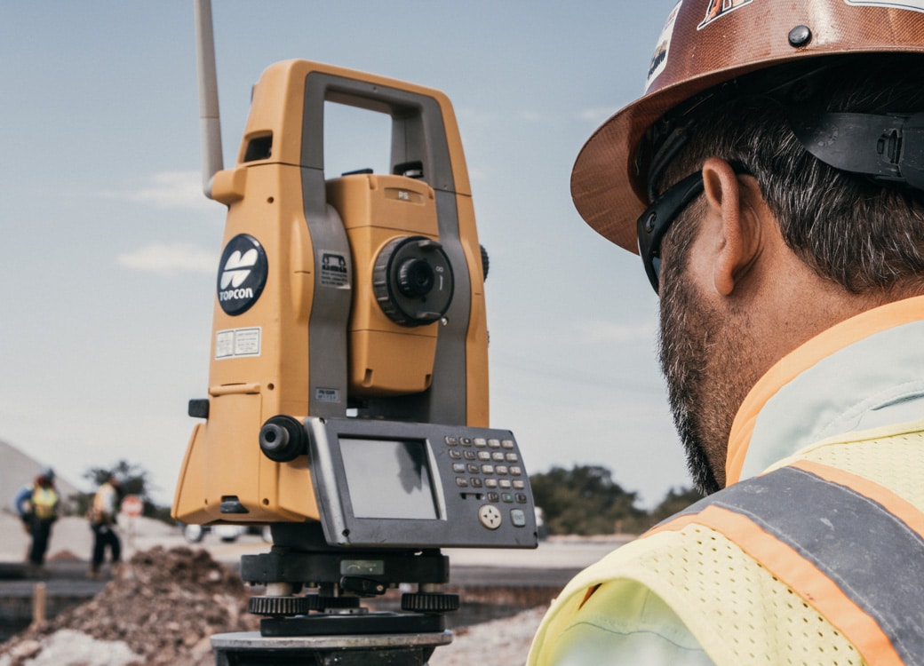 Superior Construction worker using a robotic total station